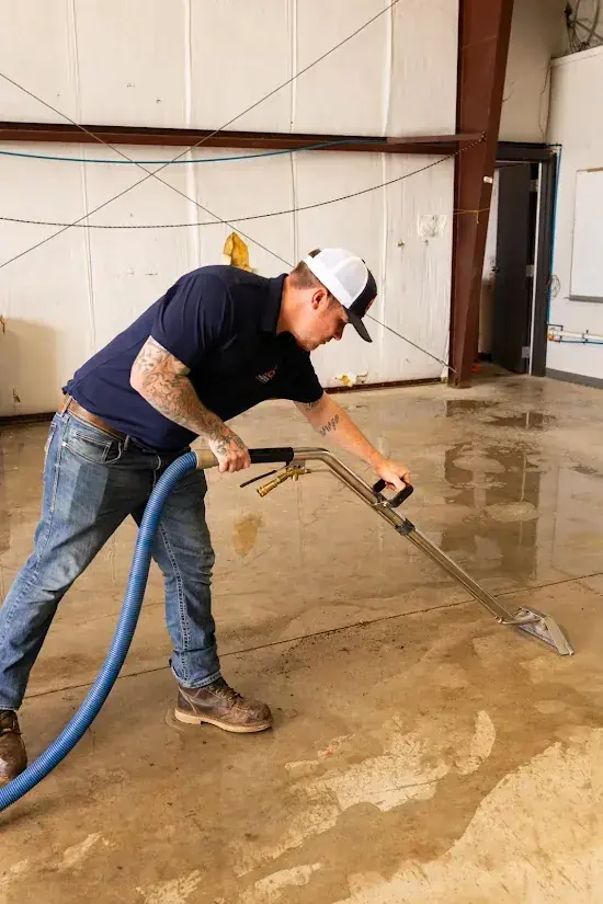 Technician extracting water from a slab leak on a Miami floor